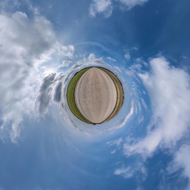 Tiny planet in blue sky with sun and beautiful clouds Transformation of spherical panorama 360 degrees Spherical abstract aerial view Curvature of space