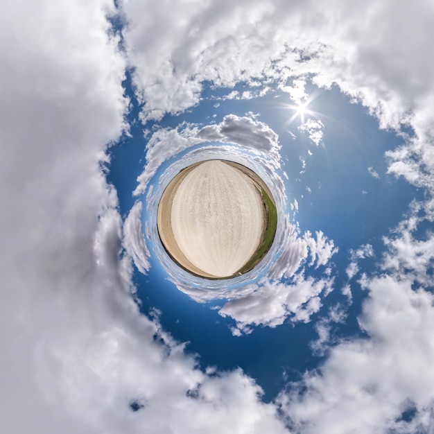 Tiny planet transformation of spherical panorama 360 degrees Spherical abstract aerial view in field with clear sky and awesome beautiful clouds Curvature of space