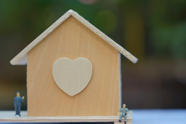 Tiny wooden house with figurines near