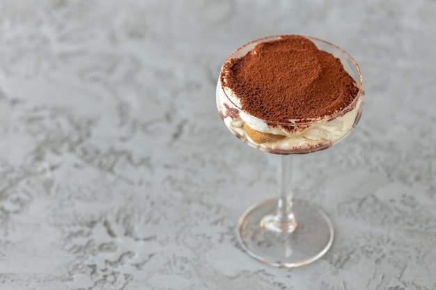 Photo tiramisu dessert in a glass on gray surface