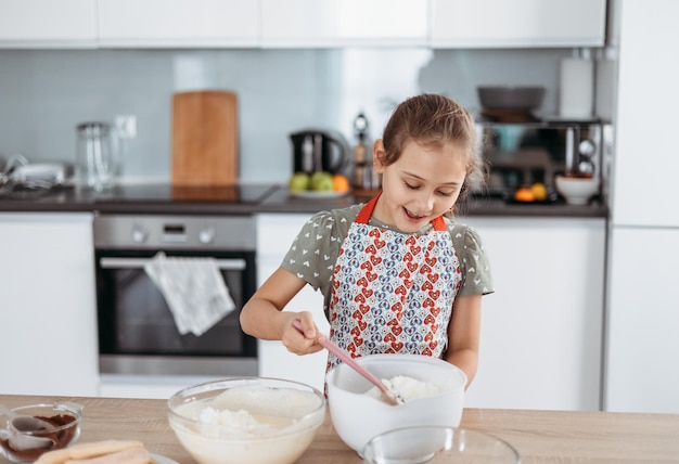 Tiramisu making process in the kitchen little girl making Italian desert with cocoa and espressodipped ladyfingers with mascarpone cream step by step 7