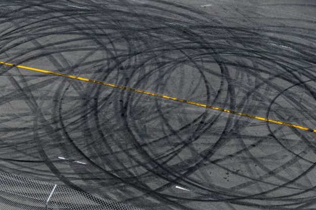 Tire track mark on asphalt tarmac road race track texture and background Abstract background black tire tracks skid on asphalt road in racing circuit Tire mark skid mark on asphalt road