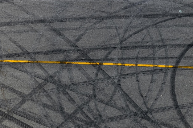 Tire track mark on asphalt tarmac road race track texture and background Abstract background black tire tracks skid on asphalt road in racing circuit Tire mark skid mark on asphalt road