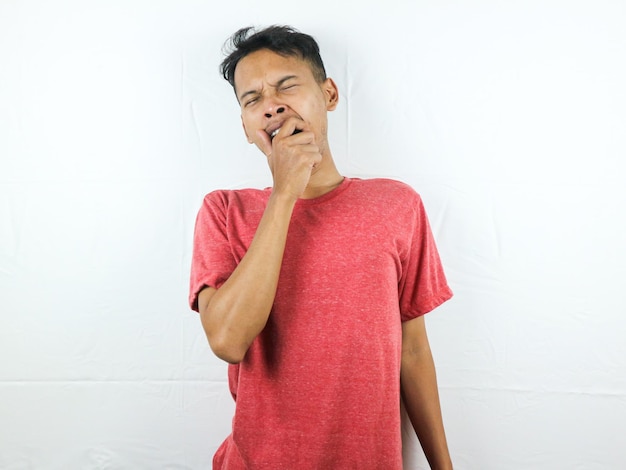 Tired asian man with yawn face expression sleepy and back pain on white background