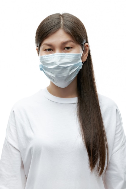 Tired asian young woman in medical mask on white background isolated