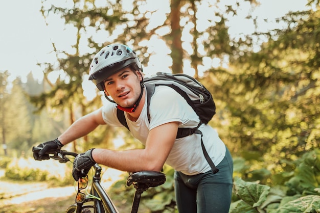 Tired bicyclist in sport clothes and helmet taking a break after outdoors training A healthy Caucasian man spending free time for a workout on the fresh air Highquality photo