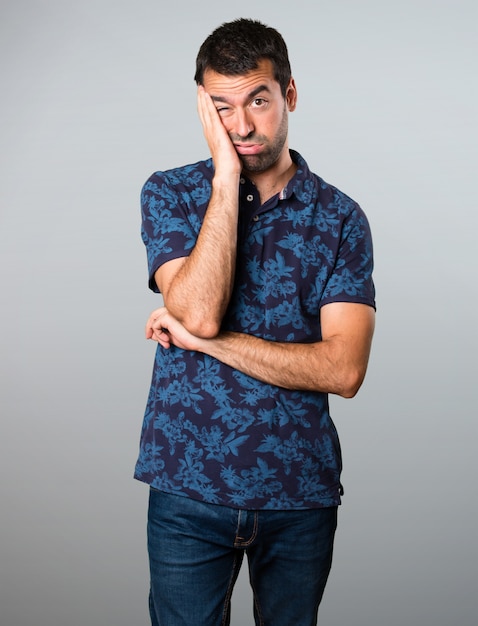 Tired brunette man on grey background