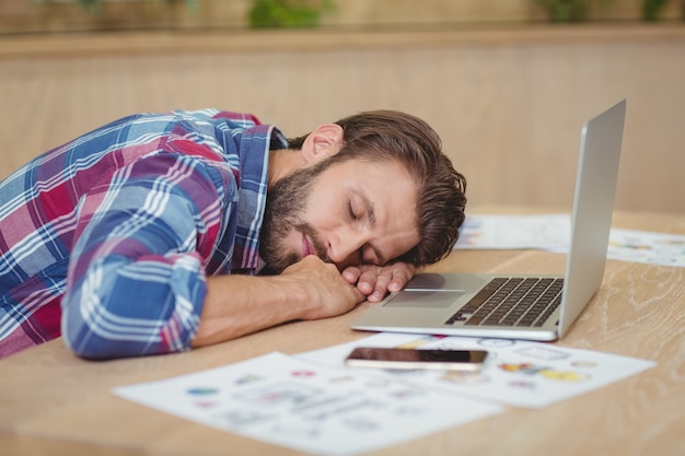 Tired business executive sleeping on desk while working