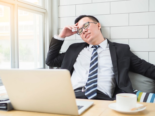 Tired business man at workplace in office holding his head on hands