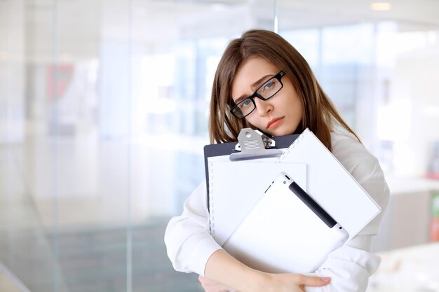 Tired business woman standing in the office