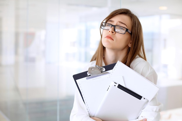 Tired business woman standing in the office