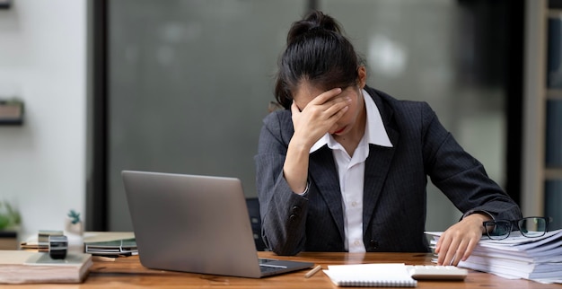 Tired business woman working on computer in modern office headache