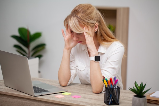 Tired business woman working with documents in the office at the desk