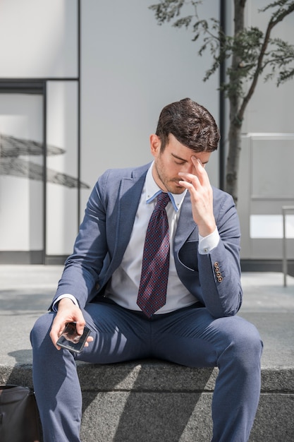 Tired businessman rubbing forehead