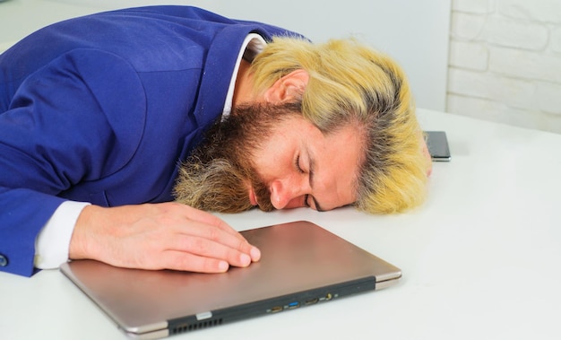 Tired businessman sleep on work desk office employee sleeping at workplace burnout and overwork