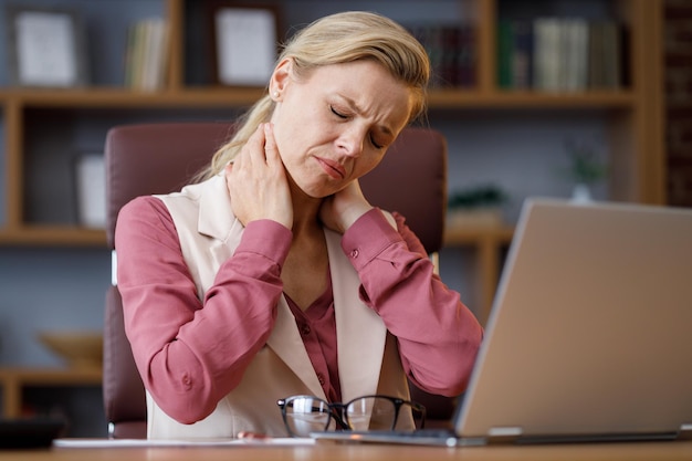 Tired businesswoman after exhausting paperwork taking off eyeglasses feeling nack pain Head ache bad vision chronic fatigue and eyestrain concept Burnout and overwork concept