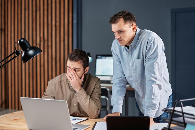 Tired colleagues working with financial documents at night