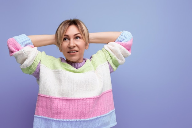 Tired cute blondie woman stretching on purple background