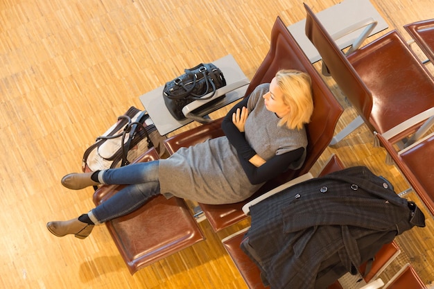 Tired female traveler waiting for departure