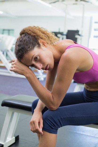 Tired fit woman taking a break on the bench