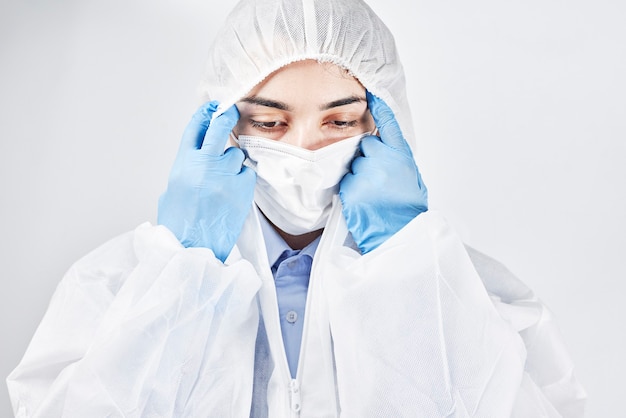 A tired and frustrated doctor taking off protective wear. Covid Combat Fatigue. Health care worker takes off personal protective equipment