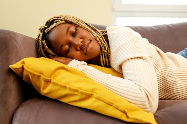 Tired latin hispanic woman taking nap on the sofa during the day