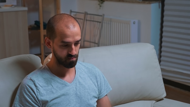 Tired man sitting in front of television writing lifestyle information