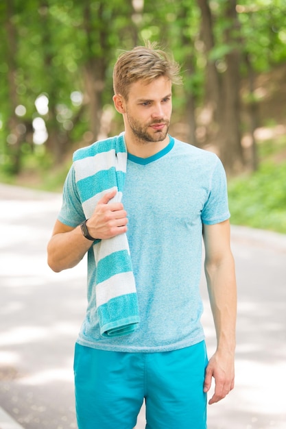 Tired man tired man with towel relax after training in forest man tired after running in park man feeling sick and tired