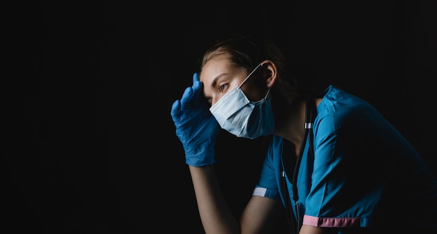 Tired medic girl on a black background