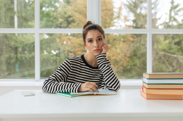 Tired pensive student girl homeschooling