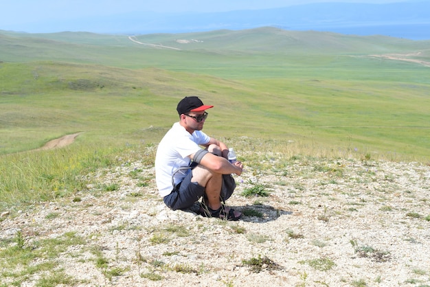 Tired Russian tourist sitting on the ground