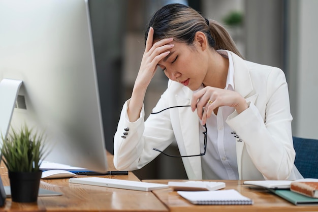 Tired stressed businesswoman at office with head in hands