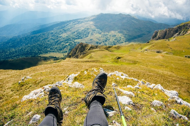 Tired tourist concept trekking boots against the backdrop of a beautiful landscape