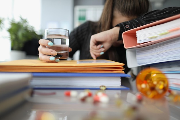 Tired woman clerk drink pill to stop headache because of big workload