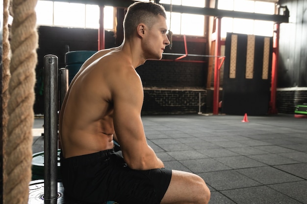 Tired young sportsman in the gym