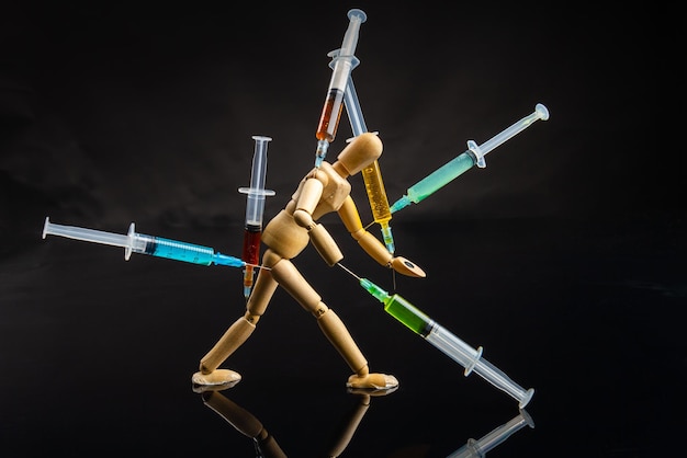 Tiredness from drugs and overdose concept wooden mannequin with stuckes syringes exhausted walking d