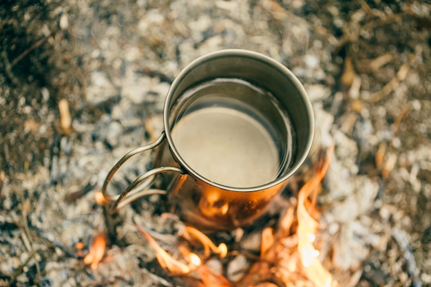 titanium cup on forest background bushcraft adventure travel tourism and camping concept