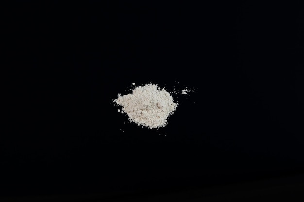 Titanium dioxide. TiO2 on dark background. Food additive E171. White chemical powder. Pigment