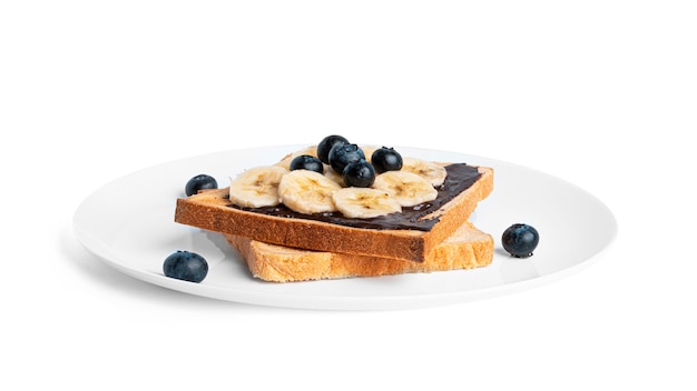 Toast bread with chocolate spread, berries and banana isolated on white.