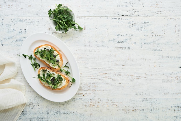 Toast or sandwich with cream cheese and micro greens peas and sunflower Concept healthy food or snack Flat lay copy space