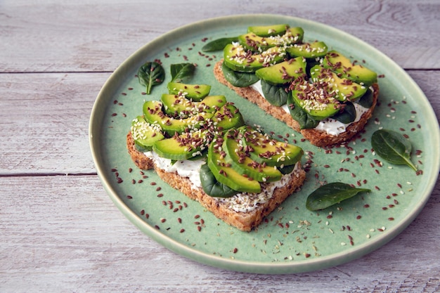 Toast with avocado cottage cheese spinach sesame seeds flax seeds Healthy food rich in fiber trace elements omega acids unsaturated lipids