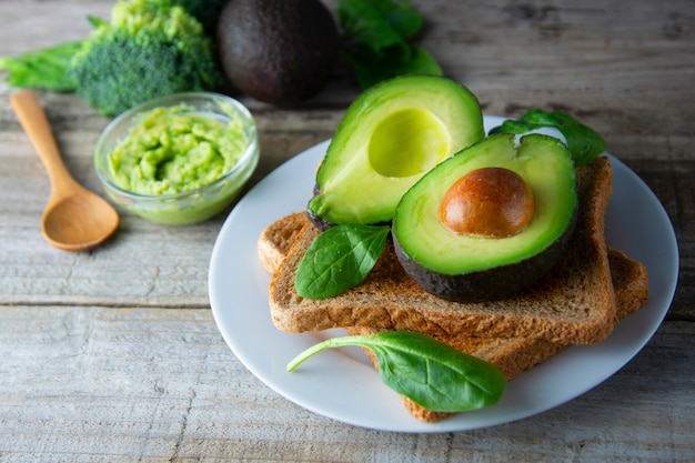 Toast with guacamole, avocado slices. Healthy food, snack. Breakfast. Wooden rustic table.