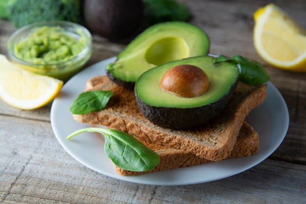 Toast with guacamole, avocado slices. Healthy food, snack. Breakfast. Wooden rustic table.