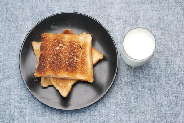 Toasted bread and glass of milk on table