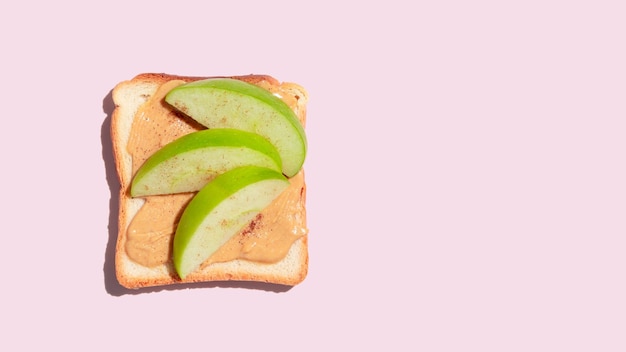 Toasted bread with apple and cinnamon on pink background