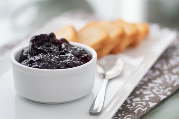 Toasts with cranberries jam and a cup of coffee on white