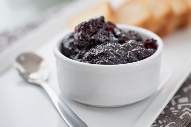 Toasts with cranberries jam and a cup of coffee on white