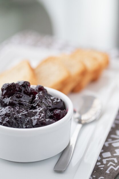 Toasts with cranberries jam and a cup of coffee on white