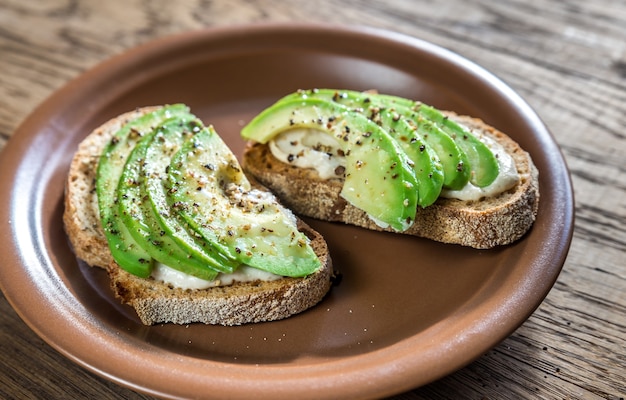 Toasts with tahini sauce and sliced avocado