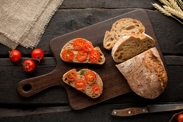 Toasts with tomatoes and bread on a board